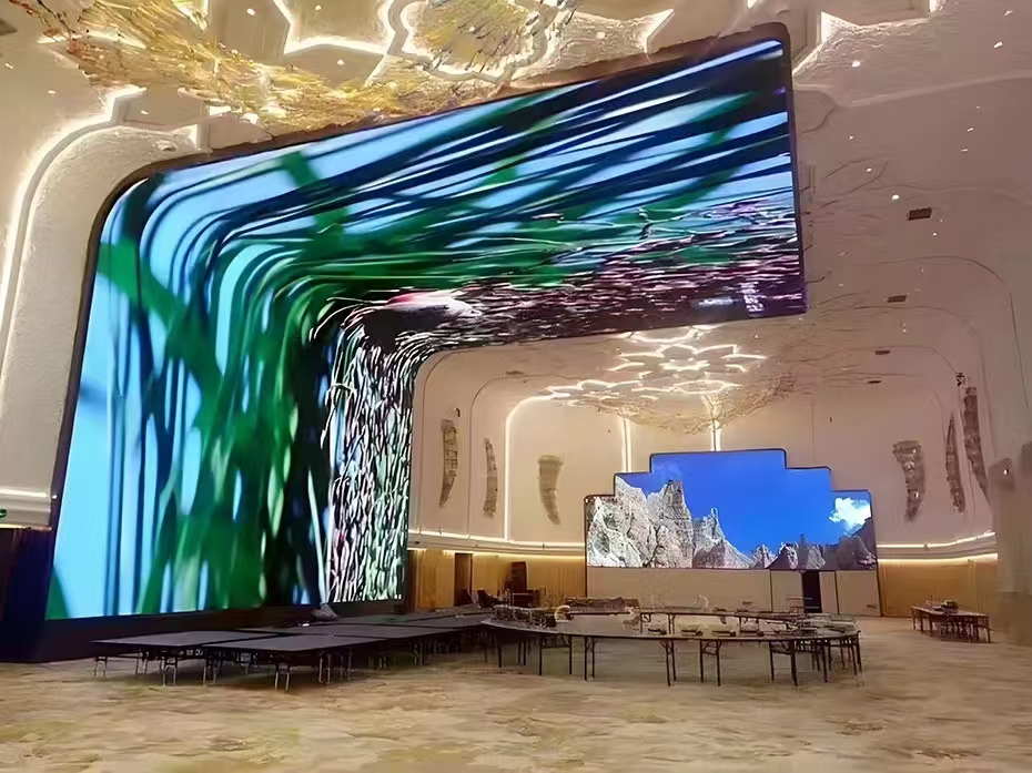 Foldable indoor LED display mounted in a hotel lobby ceiling and wall, displaying breathtaking natural landscapes