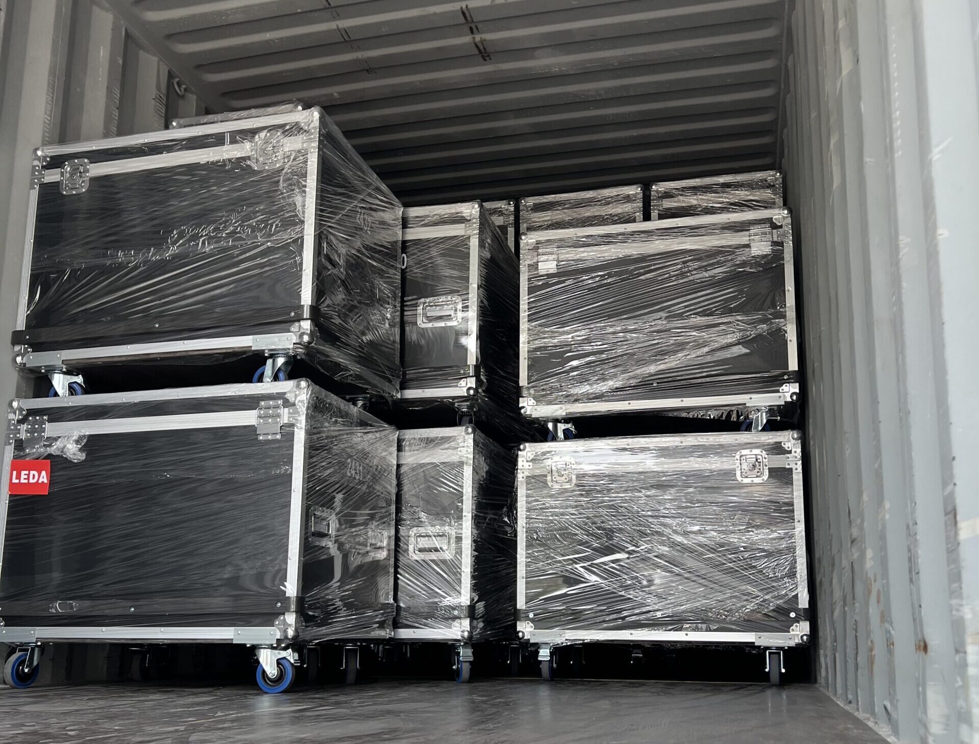 Black airline cases loaded in a shipping container for export of LED displays.